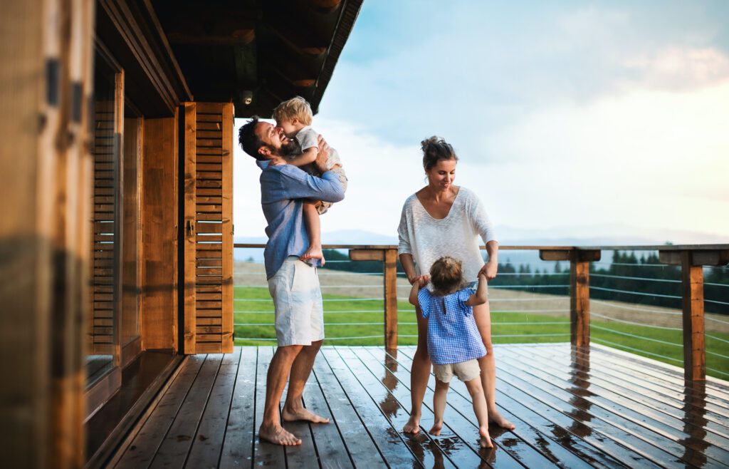 Family on the porch of cabin near the beach.